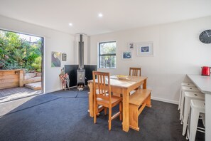 Enjoy a casual meal in this dining area with a table and chairs, featuring a large window and a wall-mounted clock.