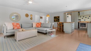 A modern living room with a grey sofa, a wooden coffee table, and a striped rug.