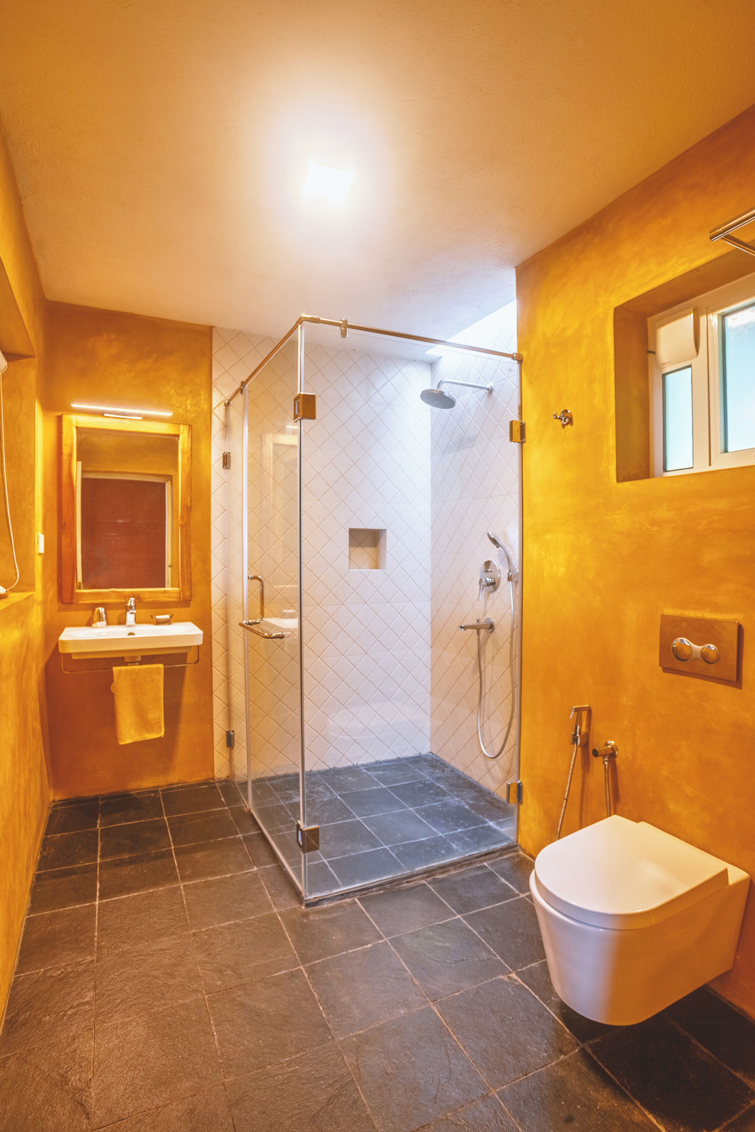 Une salle de bain avec une douche à parois de verre, un lavabo et des toilettes.