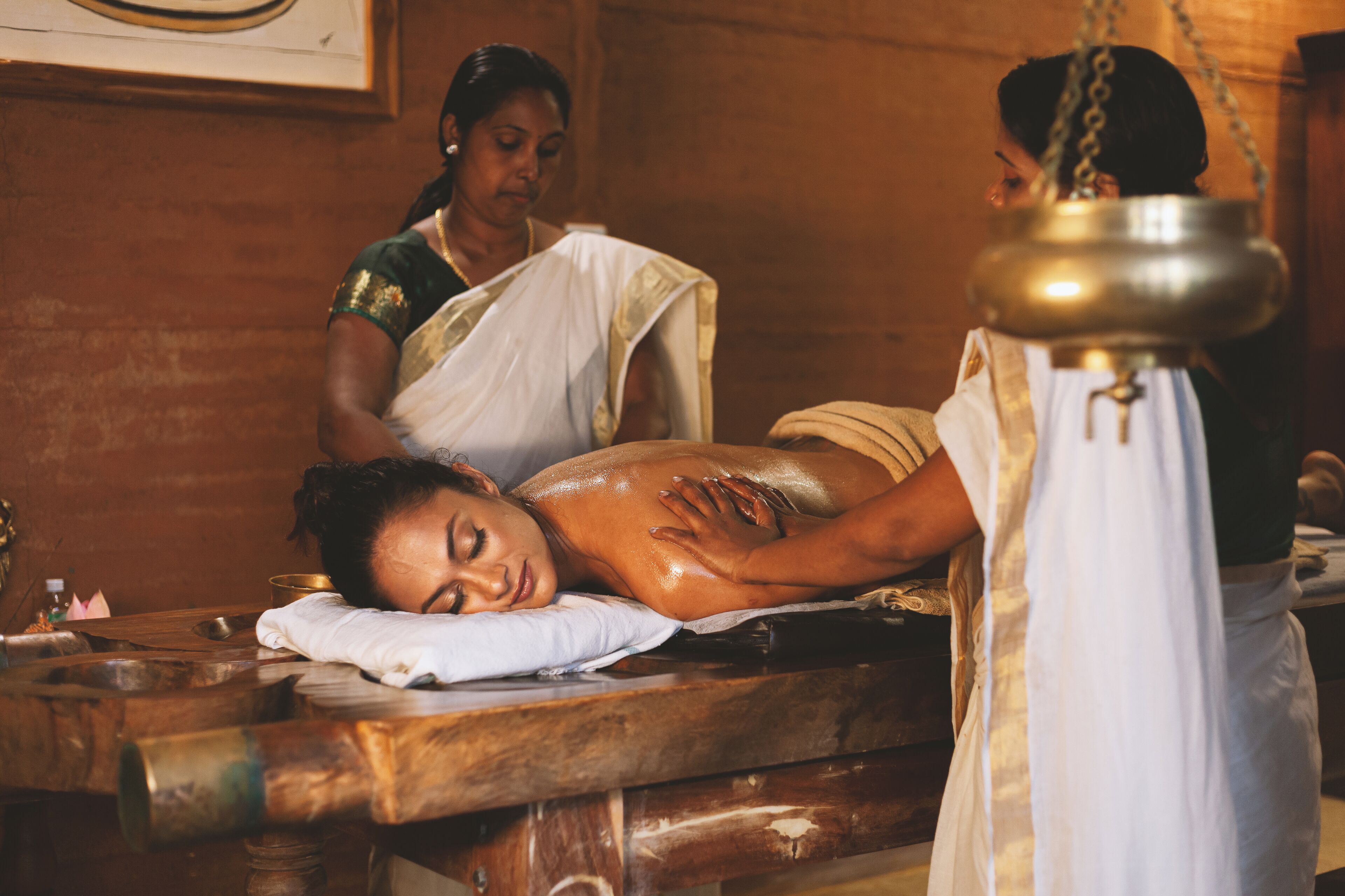 Une séance de massage dans une salle aux meubles en bois et à l’ambiance traditionnelle.