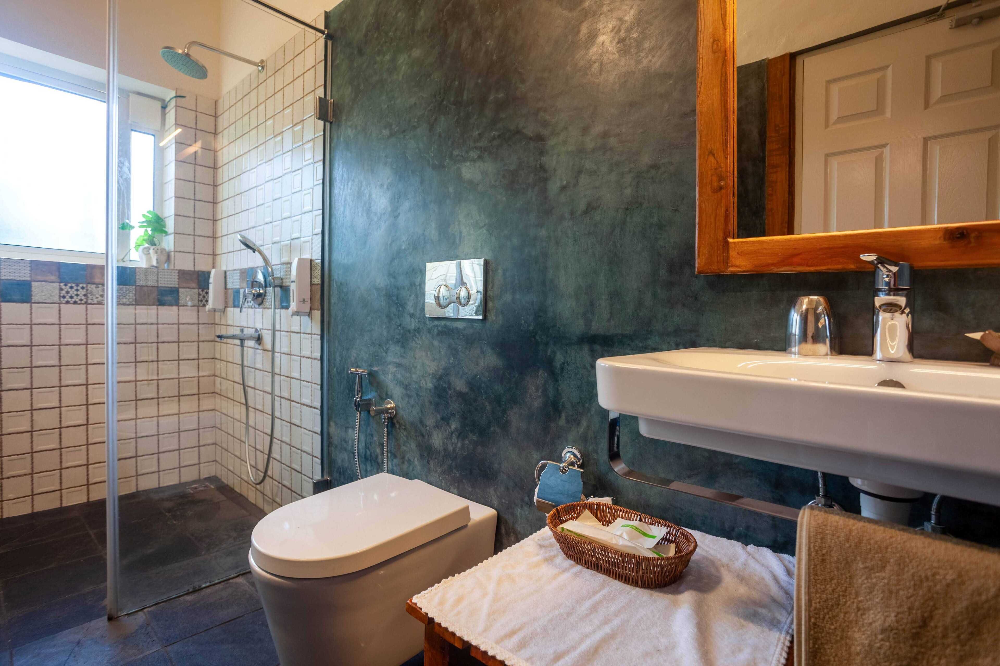 A bathroom with a shower, toilet, sink, and a towel rack.