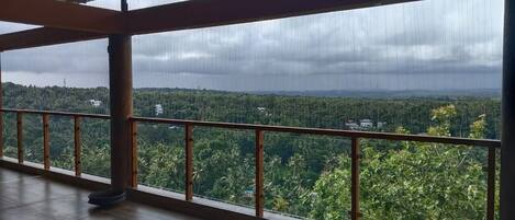 Ein Zimmer mit großem Fenster und Blick auf ein bewaldetes Gebiet.