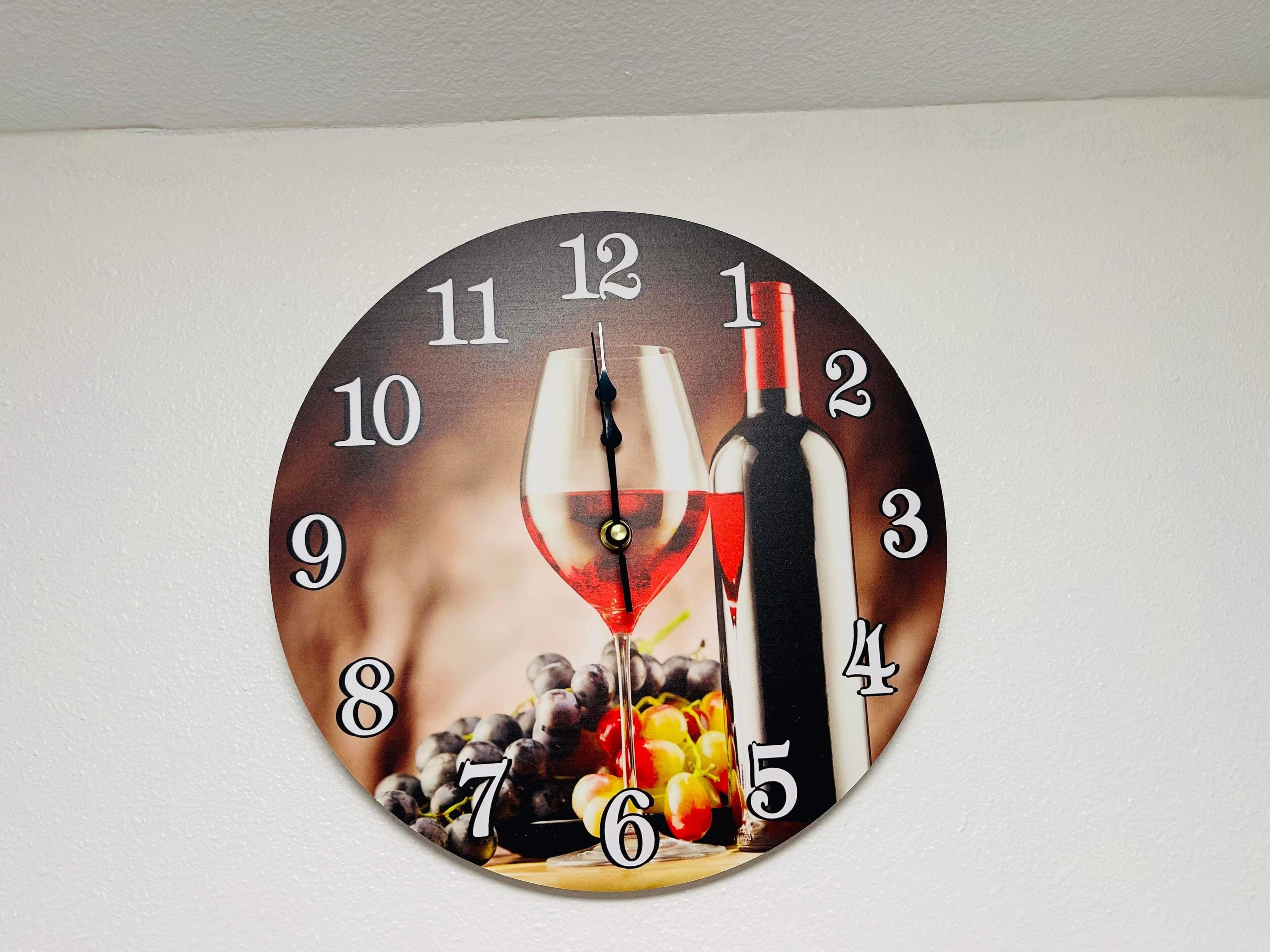 Un reloj de pared con diseño de copa y botella de vino.