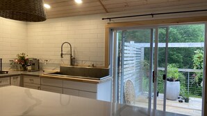 A modern kitchen with a large island, a built-in sink, and a view of the outdoor deck through glass doors. - Cute Loft , Ideal Location to Bayside Camden and Belfast
Day trip to Bar Harbor! (Northport)