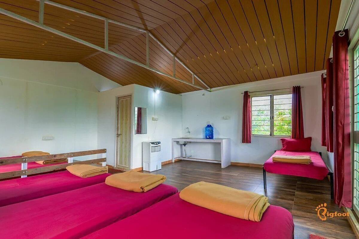 A room with two beds, a desk, and a window.