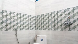 A bathroom with a toilet, shower, and a small window. - Mussoorie (Dehradun)