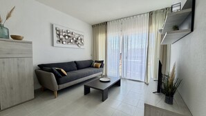 Una sala de estar moderna con un sofá, una mesa de centro y un televisor.