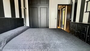 A bedroom with a bed, a wardrobe, and a door leading to another room. - SALLES BEACH 3 (Estartit)