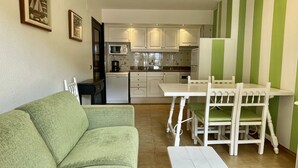 A compact living space with a kitchenette, a dining area with a table and chairs, and a sofa. - SALLES BEACH 3 (Estartit)