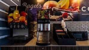 Eine Kaffeemaschine mit verschiedenen Getränkeauswahlen und eine Mikrowelle auf einer Arbeitsfläche.