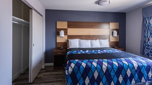 Ein Hotelzimmer mit einem großen Bett, einem Holz-Kopfteil, zwei Nachttischen mit Lampen und einem Kleiderschrank.