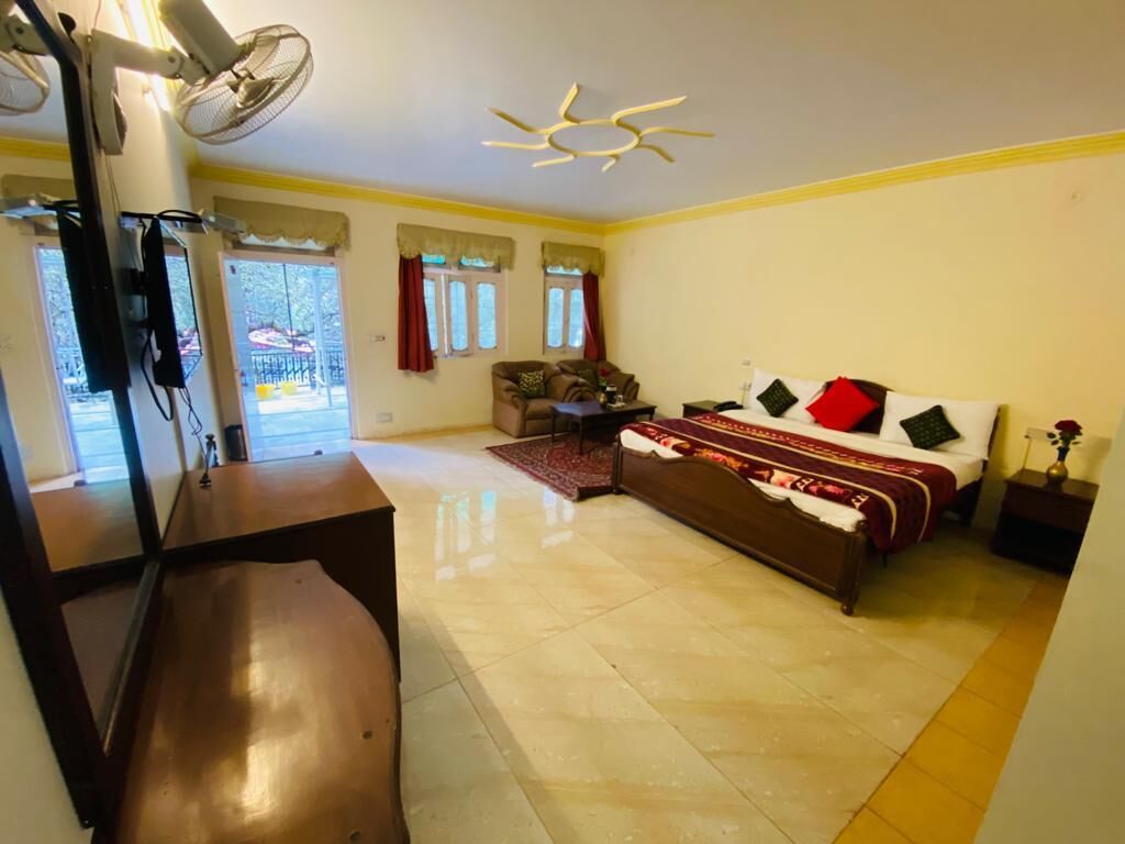 A bedroom with a bed, bedside tables, a ceiling fan, and a window with curtains.