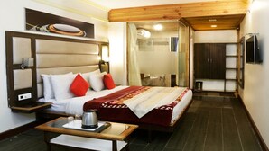 Quarto de hotel com cama, mesa de cabeceira e espelho.