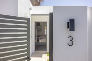 Moderni rakennus, jossa on numero kolme (3) -merkki, metallinen portti ja ovi, joka johtaa sisätilaan.