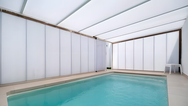 A swimming pool with a tiled floor, white walls, and a ceiling with horizontal beams. - Casita Meraki 3 with Heated Indoor Pool, Garden, Terrace, and Wi-Fi (Chiclana de la Frontera)