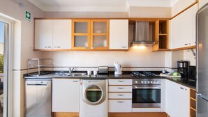 Una cocina moderna equipada con lavavajillas, lavadora, estufa y horno.