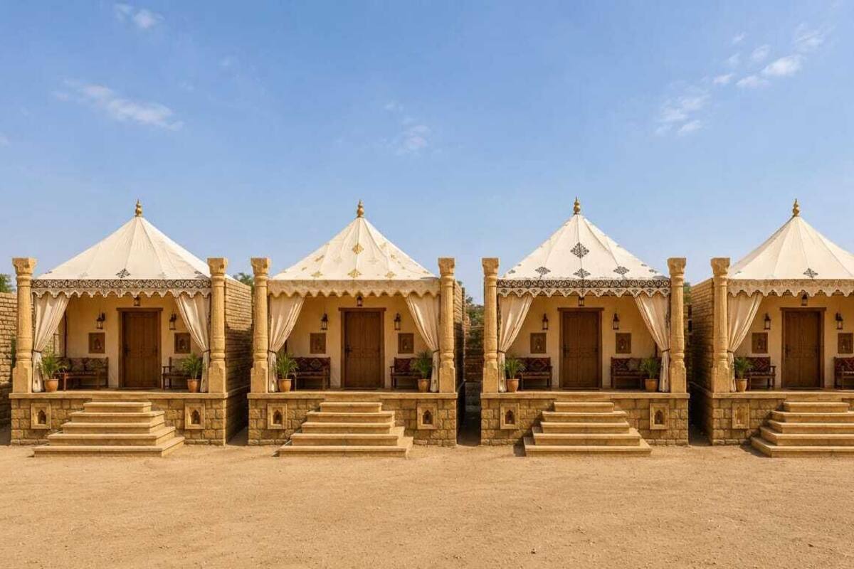 A row of four identical tents with a central doorway, each with a set of steps leading up to the entrance.