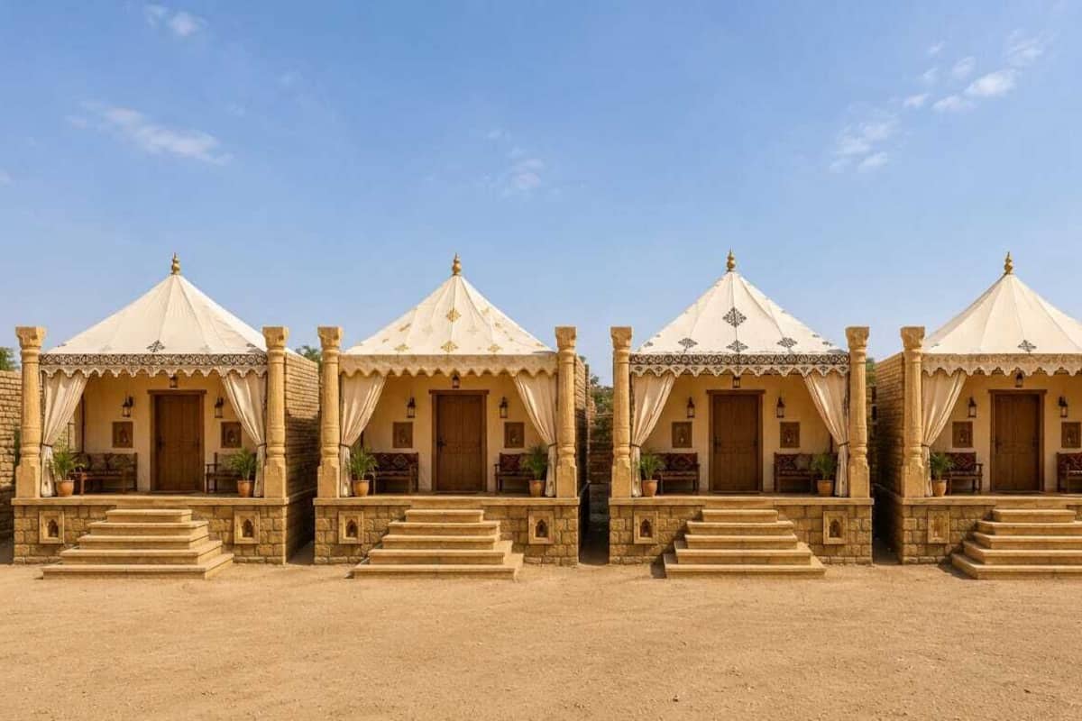 Une rangée de quatre tentes identiques, dotées d’une porte centrale, chacune étant accessible par un petit escalier menant à l’entrée.