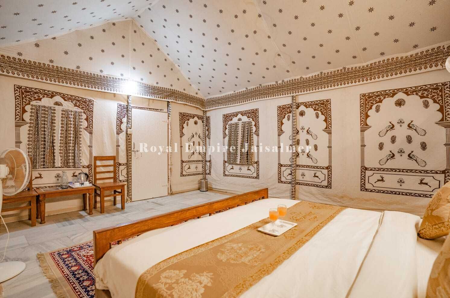 Ein traditionell eingerichtetes Zimmer mit Bett, Stuhl, Ventilator und Wandverkleidung mit Muster.