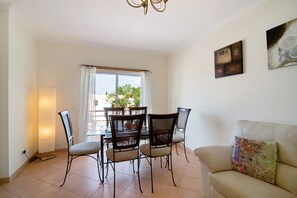 Un comedor con una mesa, sillas, un sofá y obras de arte en las paredes.