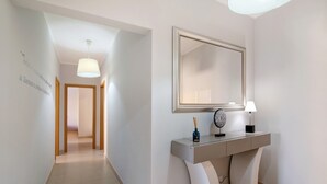 A hallway with a modern console table, a mirror, and a lamp.