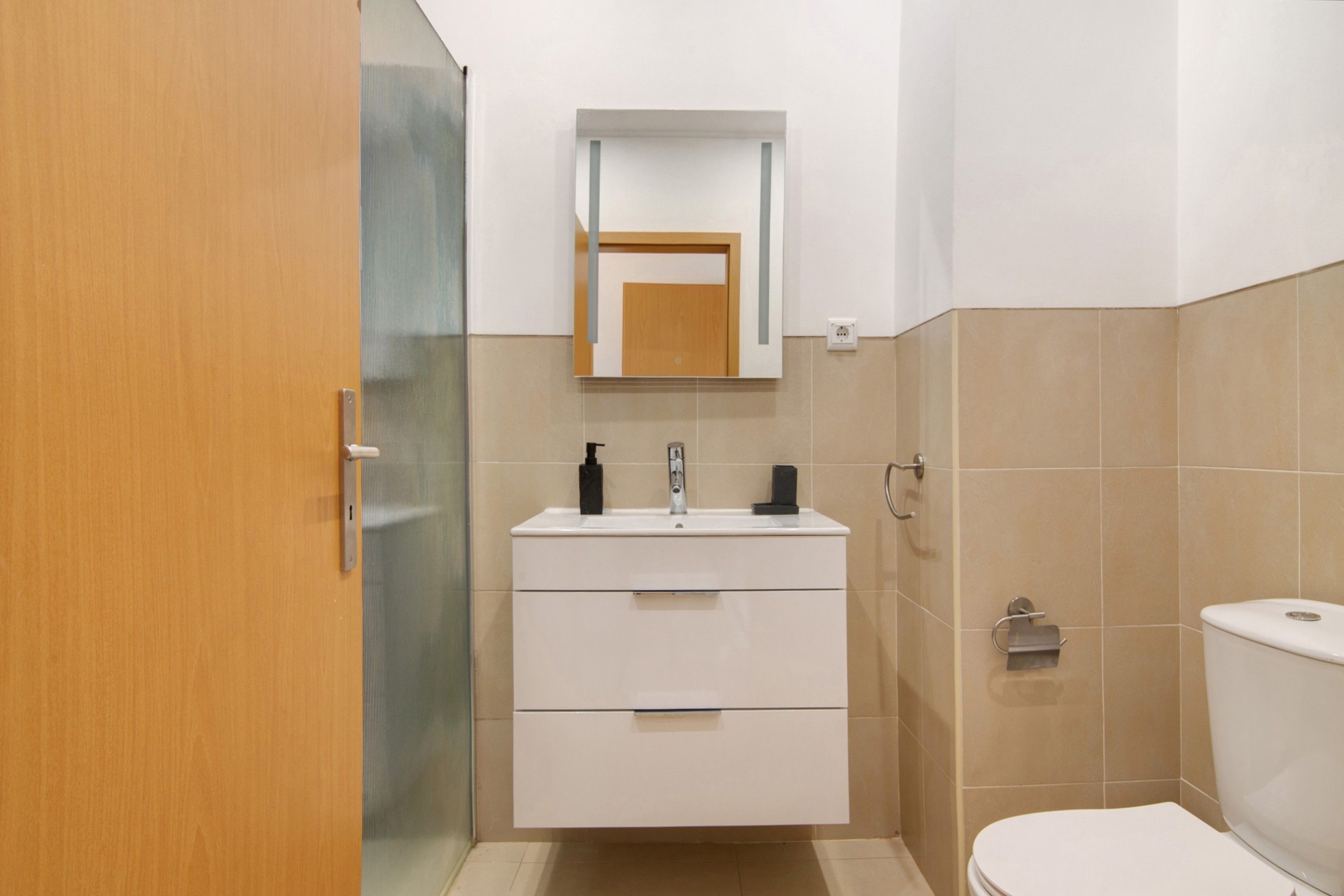 Une salle de bain avec des toilettes, un lavabo et un miroir.