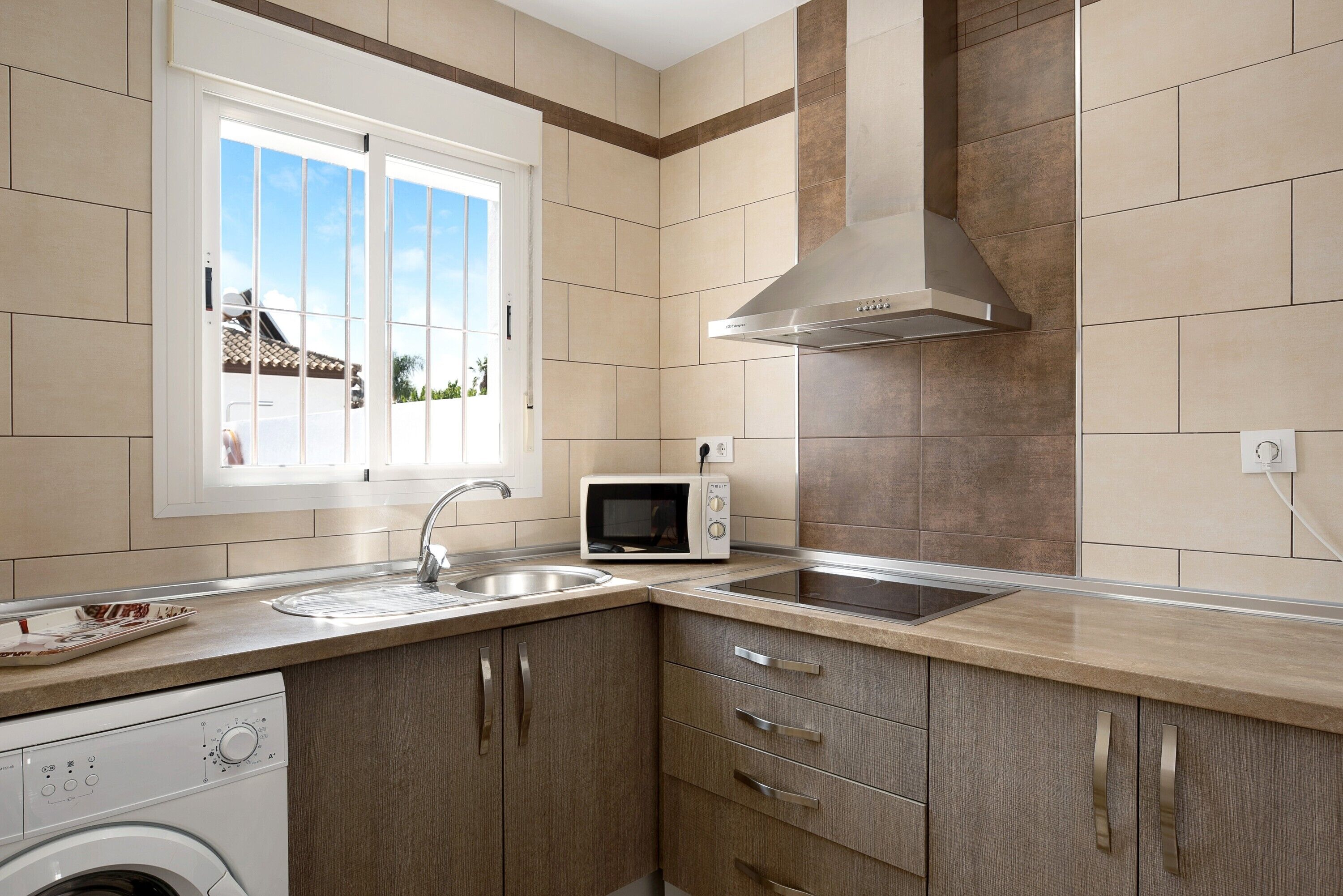 A kitchen with a microwave, sink, and dishwasher.