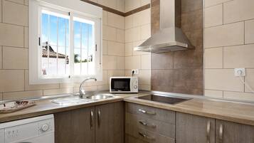A kitchen with a microwave, sink, and dishwasher.