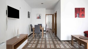 A hallway with a dining area, a TV mounted on the wall, and a patterned floor. - Holiday Home 'Casa Cala Del Aceite 2' with Private Pool, Private Terrace and Wi-Fi (Conil de la Frontera)
