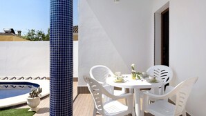 A poolside area with a white table and chairs, a blue tiled column, and a small pool. - Holiday Home 'Casa Cala Del Aceite 2' with Private Pool, Private Terrace and Wi-Fi (Conil de la Frontera)