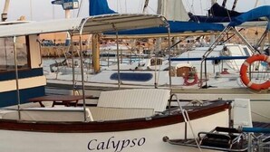 A boat named 'Calypso' docked at a marina with other boats, a lifebuoy, and a covered seating area. - Apartment "Casa di Marika" with Private Terrace and Air Conditioning (marina di leuca)