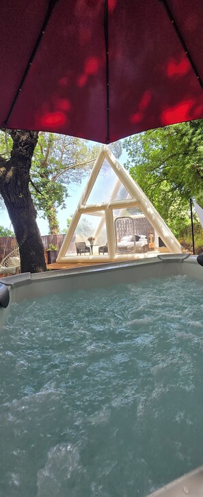 A hot tub with a triangular canopy, surrounded by trees and a wooden deck. - Bubble Glamping Sicily (Trecastagni)