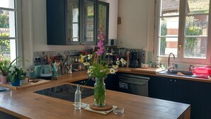 Una cocina con encimeras de madera, un fregadero y un ventanal con vistas a un jardín.