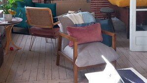 Una sala de estar acogedora con chimenea, asientos cómodos y un ordenador portátil sobre una mesa.