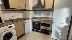 Cocina compacta con lavadora, horno y lavavajillas integrado.
