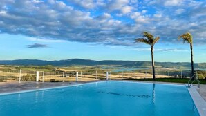 Ein Schwimmbecken mit Blick auf ferne Berge und einen klaren Himmel.