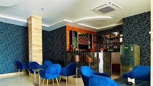 A modern dining area with blue chairs and a bar counter. - Asian Buddha Hotel (Siddharthanagar)