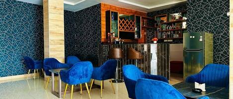 Un espace repas moderne avec des chaises bleues et un comptoir de bar.