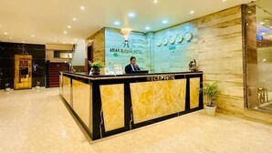 A reception area with a marble floor, a reception desk, and a wall with clocks and a sign for the Asian Buddha Hotel. - Asian Buddha Hotel (Siddharthanagar)