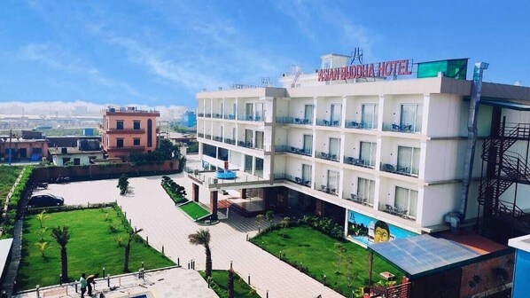 A multi-story hotel with a flat roof, balconies, and a swimming pool. - Asian Buddha Hotel (Siddharthanagar)