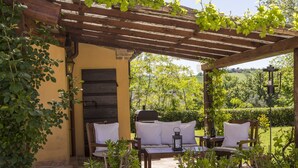 An outdoor patio with wooden furniture, potted plants, and a pergola. - Villa San Marco - Homelike Villas (Torre San Marco)