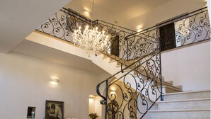 A grand staircase with ornate metal railings and a crystal chandelier. - Villa San Marco - Homelike Villas (Torre San Marco)