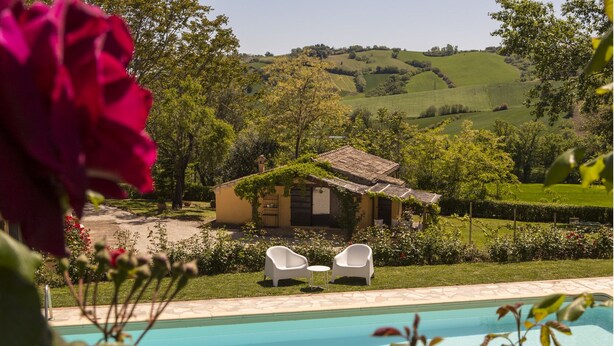A pool with two white chairs, a small house with a garden, and a view of rolling hills. - Villa San Marco - Homelike Villas (Torre San Marco)