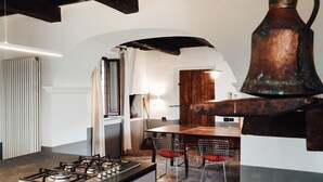 A kitchen with a gas stove, wooden table, and chairs. - Villa San Giglio - Homelike Villas (Foligno)