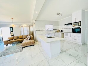 Una cocina moderna con armarios blancos, una isla central y un horno empotrado.