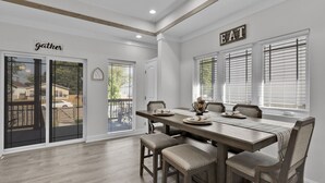 Un comedor con una mesa de madera, cuatro sillas y un letrero que dice "EAT".