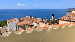 Un pueblo costero con tejados de teja y vistas al mar.