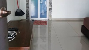 Een nette, moderne woonkamer met een houten salontafel, een rode bezem en een glazen deur met een geëtste panelen.