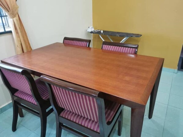 Una mesa de comedor con cuatro sillas, cada una con un cojín a rayas.