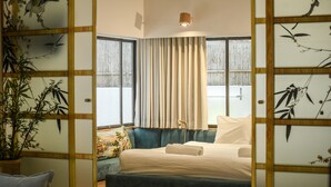 A bedroom with a bed, a sofa, and a window with curtains. - Charming 2BR Apt w a Breathtaking Patio (Tel Aviv)